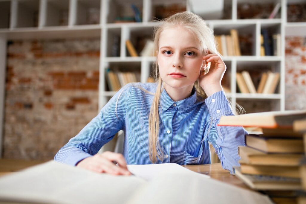 Junge Studentin in der Bibliothek aufmerksam Als Student ein Startup gründen Unsere Tipps